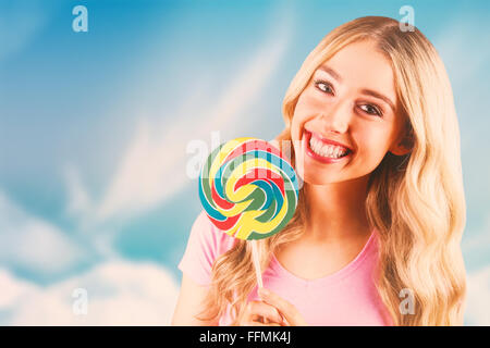 Composite image of a beautiful woman holding a giant lollipop Stock Photo