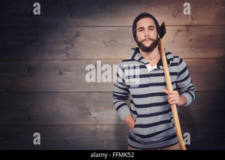 Composite image of portrait of hipster with hooded shirt holding axe Stock Photo