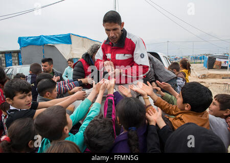 sweet distribution by a NGO to refugees in Ashdi refugee camp, Northern Iraq Stock Photo