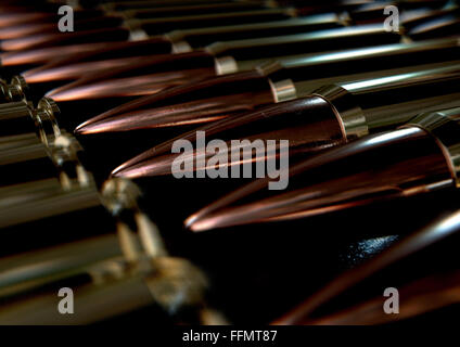 A macro close up view of a row of regular scratched brass and copper bullets on an isolated black background Stock Photo