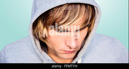 Composite image of  man in hood jacket hacking a laptop Stock Photo