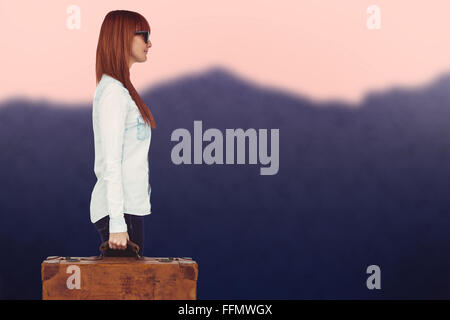 Composite image of side view of a smiling hipster woman holding suitcase Stock Photo