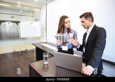 Businessman and his secretary standing and planning work in office Stock Photo