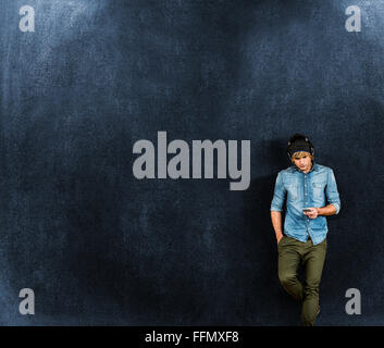 Composite image of focused hipster listening to music Stock Photo