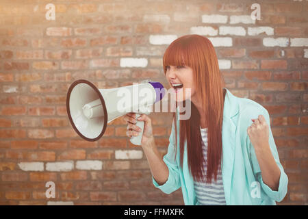 Composite image of hipster woman shooting through megaphone Stock Photo