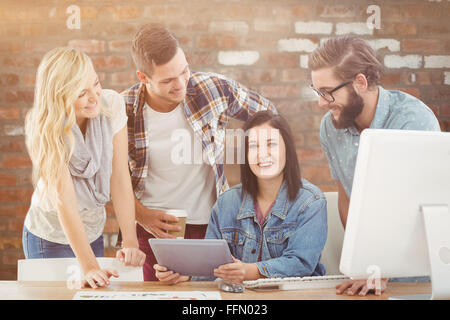 Composite image of cheerful business professionals using digital tablet Stock Photo