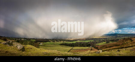 Snow storm hitting the rural Wharfedale valley with the sun's rays coming in from the left.  West Yorkshire, England Stock Photo