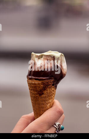 Hand holding a melting ice cream cone Stock Photo