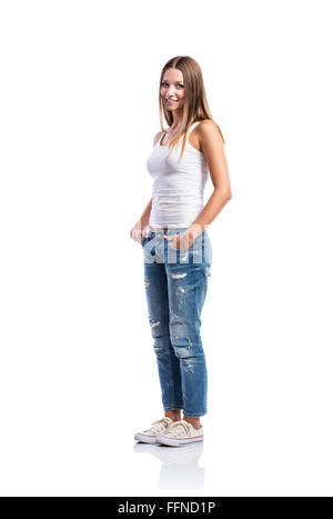 Standing teenage girl in jeans and white singlet,  isolated Stock Photo