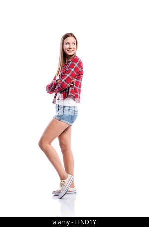 Girl in shorts and checked shirt, arms crossed, isolated Stock Photo