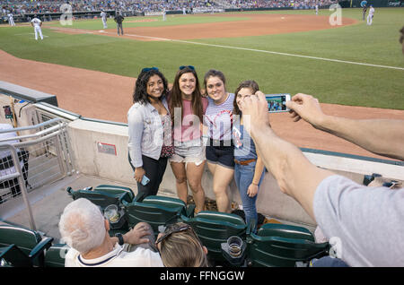 Four teenage women having their photo taken with a cell phone at Minnesota Twins baseball game. Minneapolis Minnesota MN USA Stock Photo