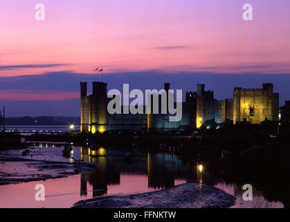 Caernarfon Castle at sunset twilight dusk night with river Seiont at low tide Gwynedd North Wales UK Stock Photo