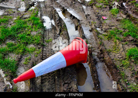 Muddy tyre tracks with traffic cone Stock Photo