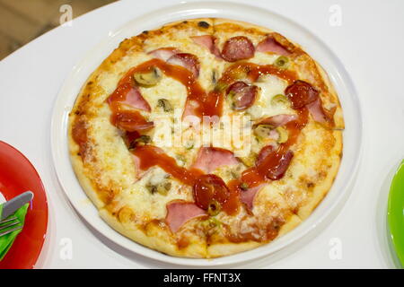 small pizza with a heart drawn with ketchup on a plate Stock Photo