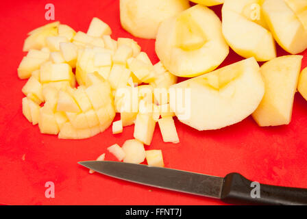 cutting apples for cake on a red chopping board Stock Photo