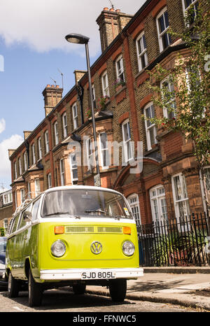 Old vintage green van parked in a street with Victorian houses in the background Stock Photo