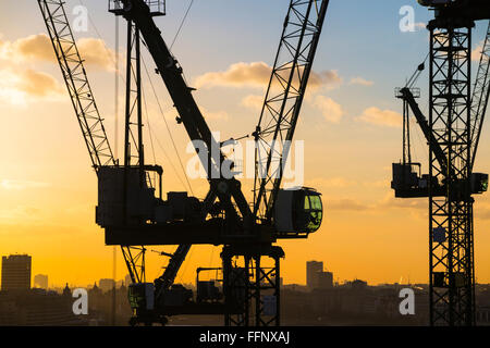 Tower cranes on the new Bloomberg Place office development in the City of London, EC4 silhouetted on the skyline at sunset Stock Photo