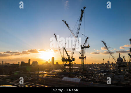 Tower cranes on the new Bloomberg Place office development in the City of London, EC4 silhouetted on the skyline at sunset Stock Photo