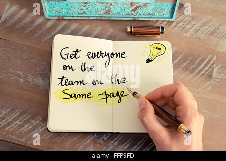Written text GET EVERYONE ON THE TEAM ON THE SAME PAGE next to yellow lighting bulb as symbol for idea Stock Photo