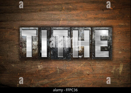 The word "Tithe" written in vintage metal letterpress type on an aged wooden background. Stock Photo