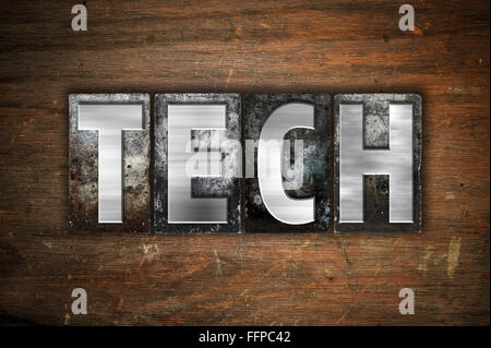 The word 'Tech' written in vintage metal letterpress type on an aged wooden background. Stock Photo