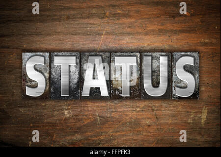The word "Status" written in vintage metal letterpress type on an aged wooden background. Stock Photo