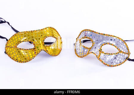 Two masks placed on a white background, a silver and the other gold Stock Photo