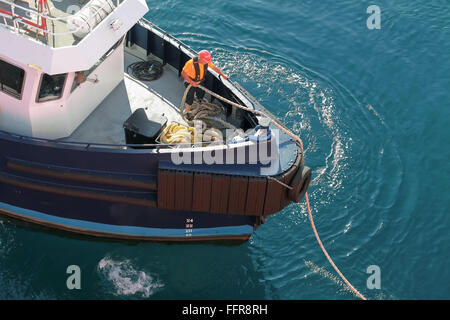 Ajaccio, France - June 30, 2015: Mooring operations, man at work with ropes on a bow of tugboat Stock Photo