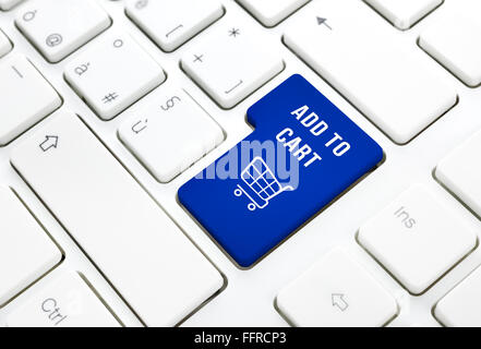 Shop on line add to cart business concept, Blue shopping cart button or key on white keyboard photography. Stock Photo