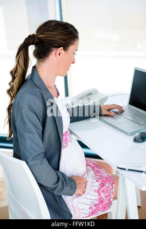pregnant business woman on her laptop Stock Photo