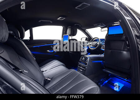 Car interior luxury. Comfortable modern black salon with multimedia & blue ambient light. Cleaning and detailing car service. Stock Photo