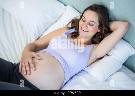 Pregnant woman lying in bed Stock Photo