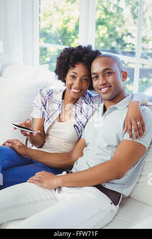 Happy couple using smartphone on the sofa Stock Photo