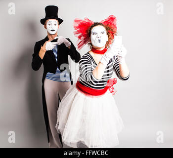 Funny couple of mimes taking a selfie photo on a mobile phone. Concept of  April Fools Day. Stock Photo