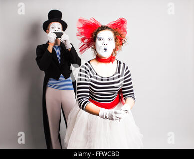 Funny couple of mimes taking a selfie photo on a mobile phone. Concept of  April Fools Day. Stock Photo