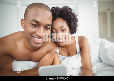 Smiling couple using smartphone Stock Photo