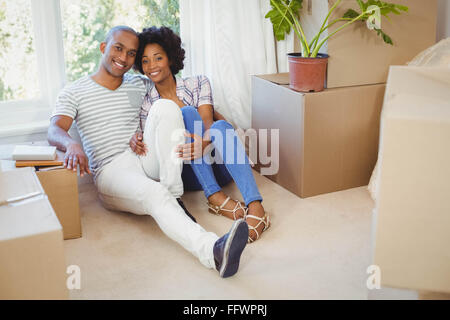 Happy couple sitting on the floor Stock Photo