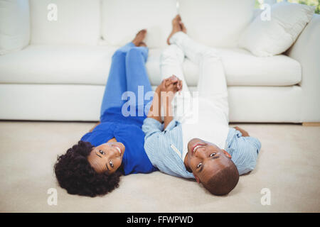 Happy couple lying on the floor Stock Photo