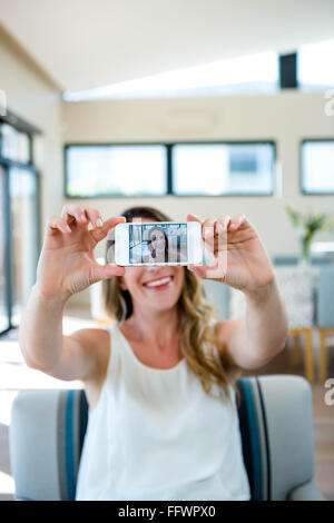 smiling woman taking a selfie on her mobile phone Stock Photo