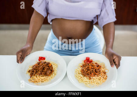 Pregnant woman with plate of pasta Stock Photo