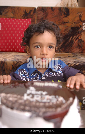 South Asian Indian small boy of 3 years sitting in front of his birthday cake MR#468 Stock Photo