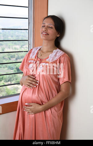 Indian young pregnant woman hand on belly - Model Release # 687Q - ang 109060 Stock Photo