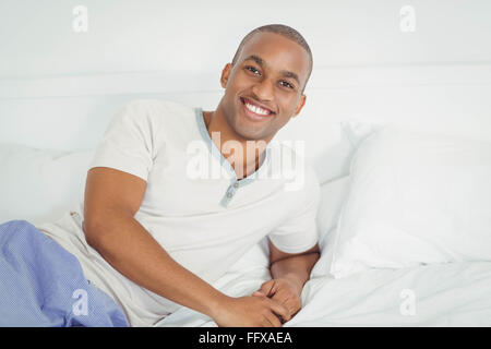 Handsome man lying on bed Stock Photo