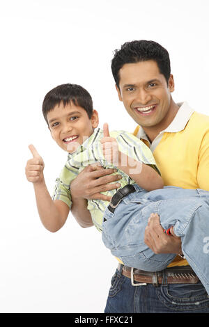 Father lifting and holding son in arm showing fists with thumb open MR#703N,703R Stock Photo