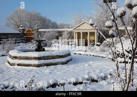 Central fountain of Cowbridge Physic Garden covered in snow under a clear blue sky Stock Photo