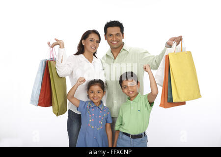 Parent showing colourful shopping bags standing with children MR#703N,703O,703R,703S Stock Photo