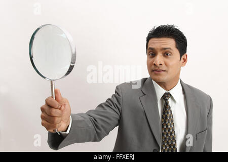 Businessman holding magnifying glass in right hand MR#703T Stock Photo