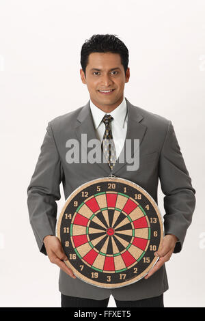 Businessman holding dart board in front of his abdomen in both hands MR#703T Stock Photo