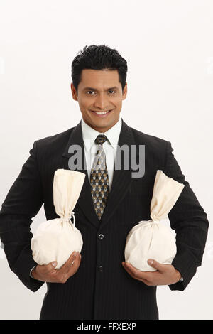 Businessman holding money bags in both hands MR#703T Stock Photo