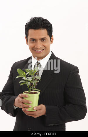 Businessman holding live plant in both hands MR#703T Stock Photo